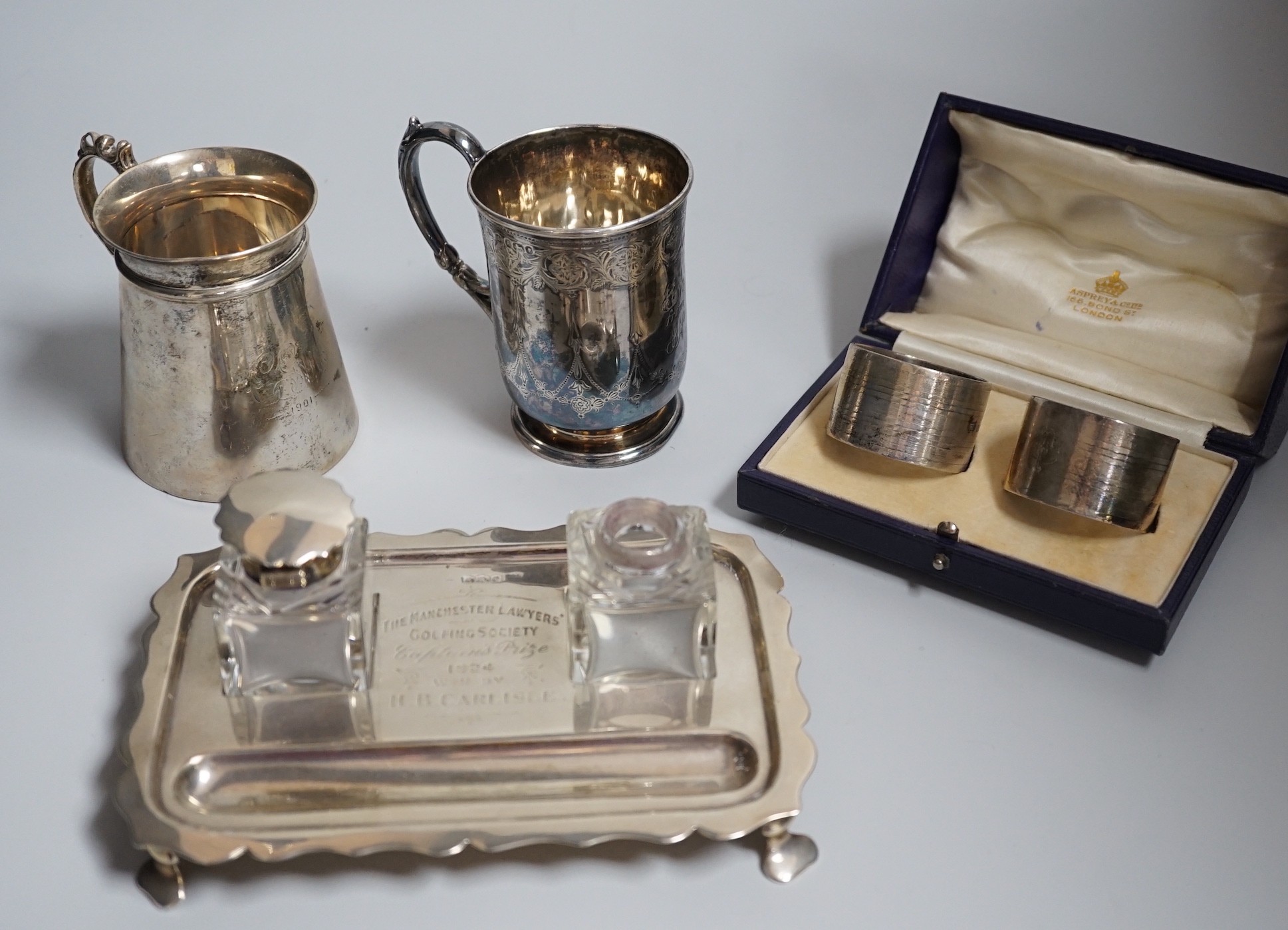 A group of silver including a George V silver inkstand, 17.7cm, a cased pair of napkin rings and two silver christening mugs, one Victorian.